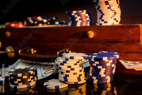 Gambling background. Colorful poker chips on playing table with wooden box for them