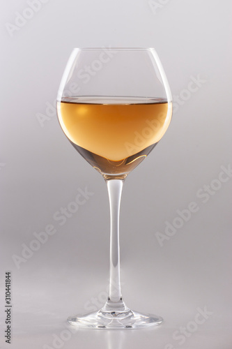 Glass of white wine on a white background and with soft shadow.