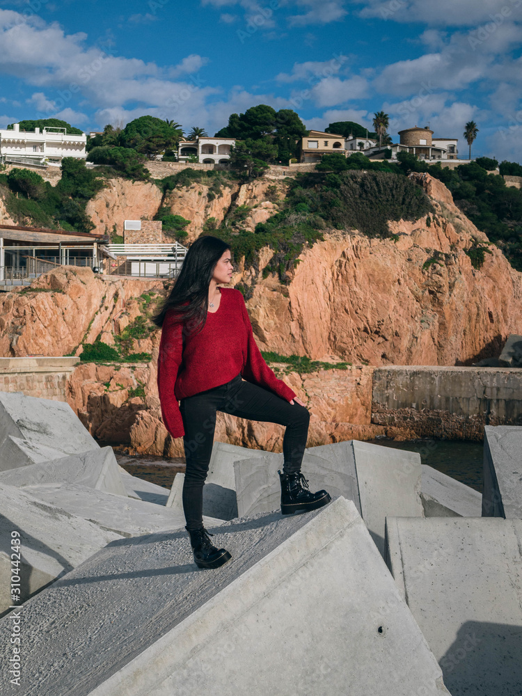 Fototapeta premium woman on rocks in harbor