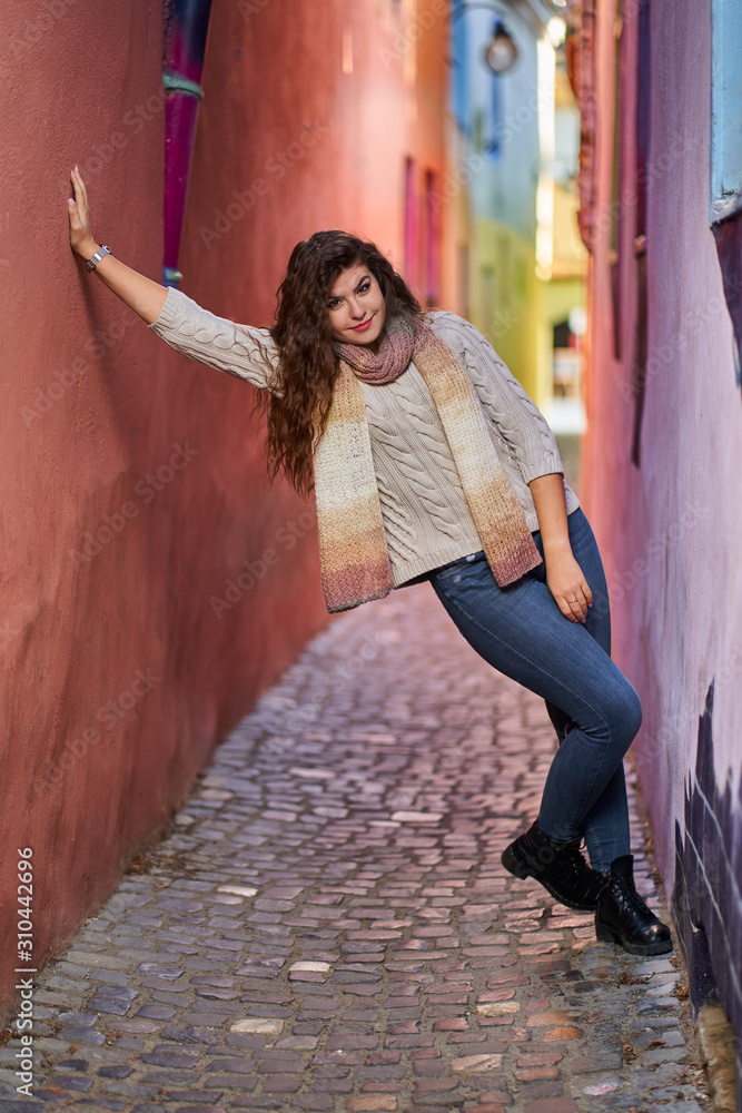 Naklejka premium Young woman on a narrow old street