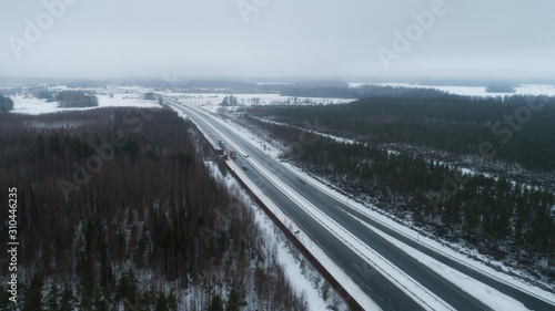 Panoramic aerial view on the Highway on a cold cloudy day in winter. Cars on the road.Drone shot.