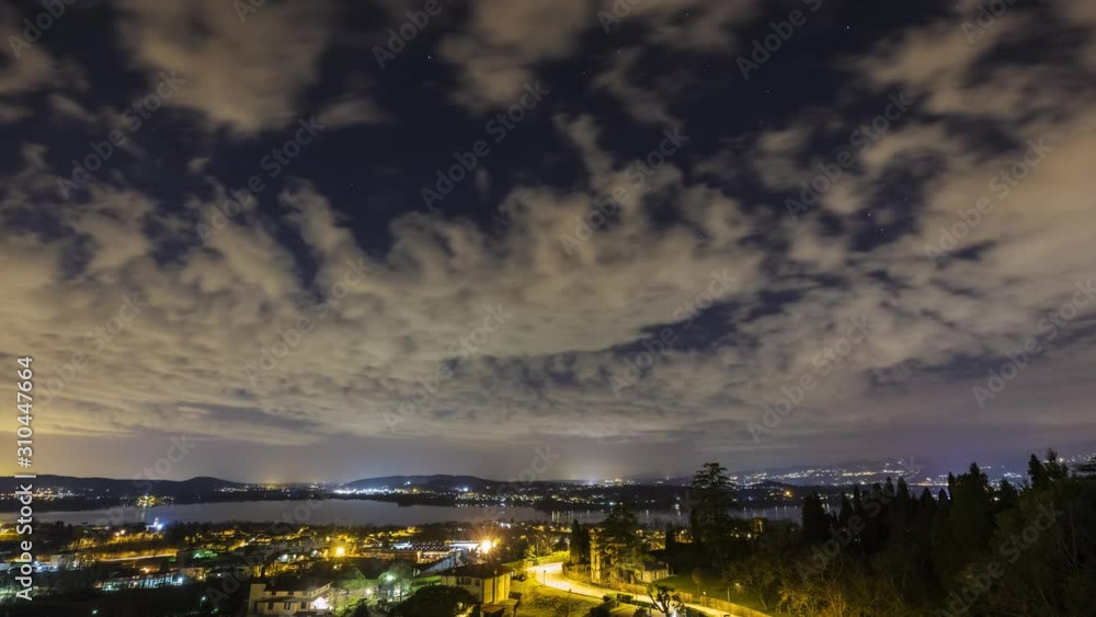 Time lapse of a panoramic view of a winter night sky with cloudy steps over cityscape with lake and hills. Time lapse of a panoramic view of a winter night sky with cloudy steps over cityscape with lake and hills.