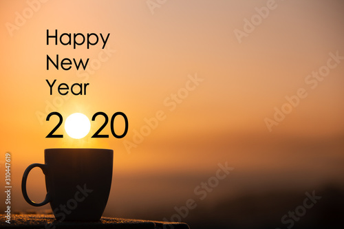 Silhouette coffee cup with happy new year 2020 text on a sunrise background