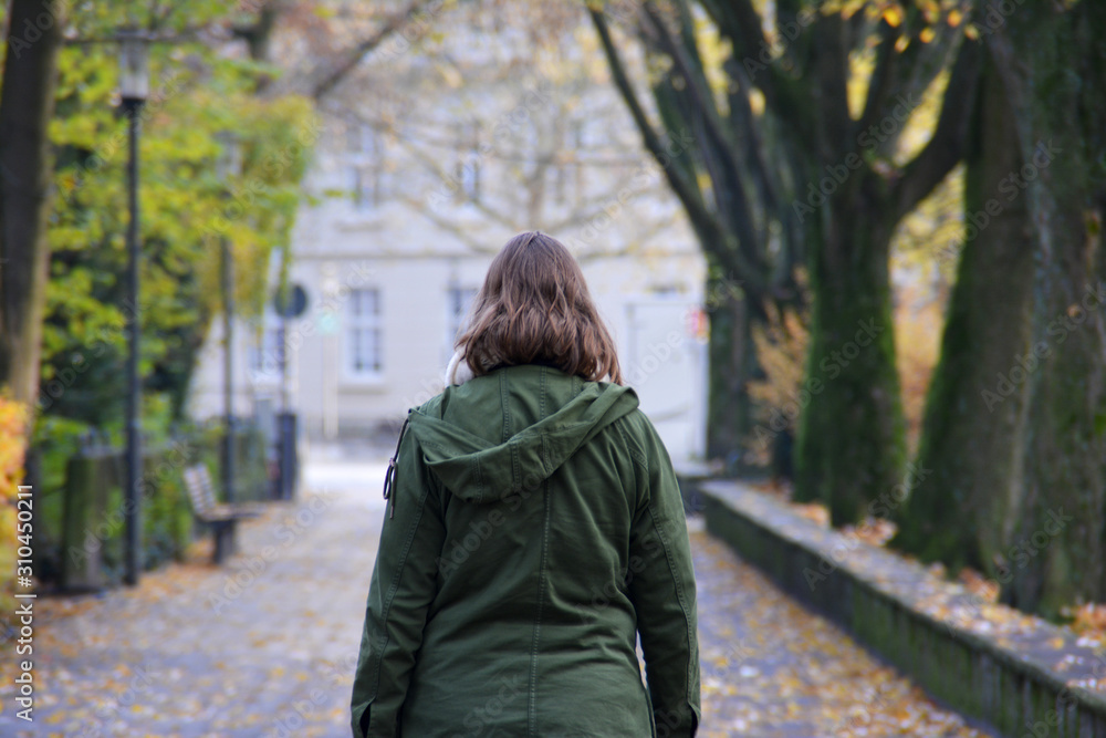 Spaziergang in Detmold - eine junge Frau in einem grünen Mantel geht im Herbst spazieren. Den eigenen Weg gehen. Seine Ziele fest im Blick haben. Blick von hinten - Rückenansicht Spaziergang in Detmold - eine junge Frau in einem grünen Mantel geht im Herbst spazieren. Den eigenen Weg gehen. Seine Ziele fest im Blick haben. Blick von hinten - Rückenansicht