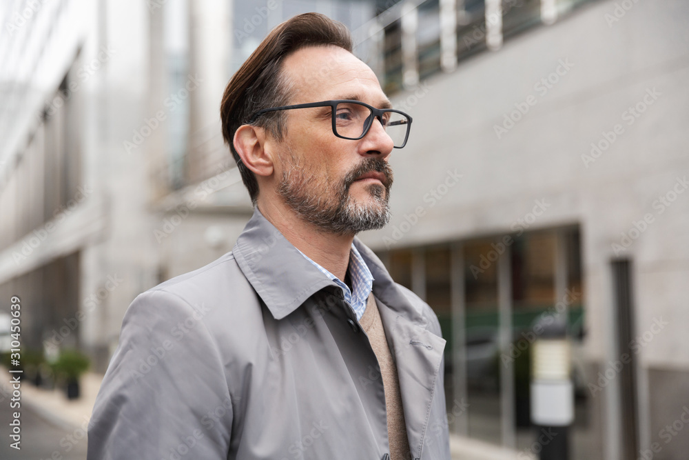 Image of mature businessman looking forward while standing Image of mature businessman looking forward while standing