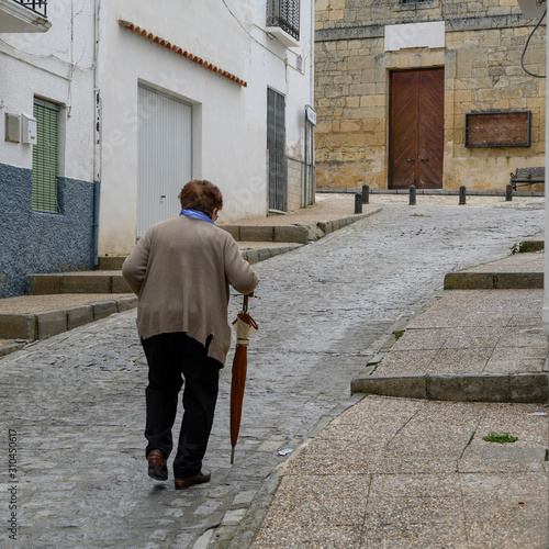 Elderly woman walking on the street, Montefr�o, Granada, Granada Province, Spain © klevit