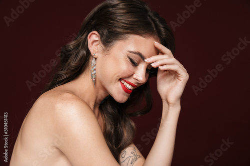 Image of joyful shirtless woman laughing and looking downward