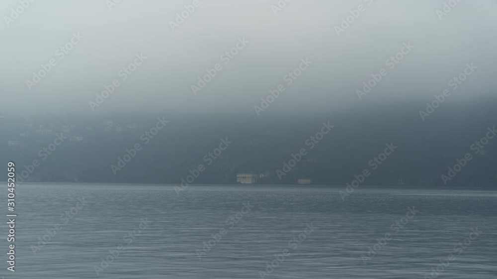 Lake Como and Villa Pliniana in the background with fog and rain in timelapse Lake Como and Villa Pliniana in the background with fog and rain in timelapse