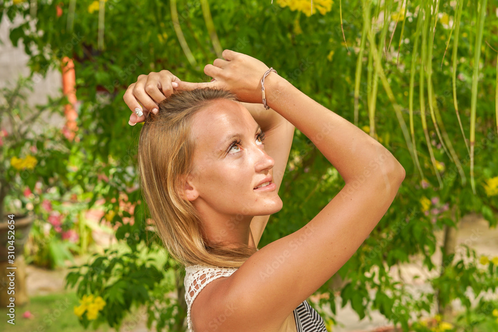 The girl posing in the tropical garden with palms The girl posing in the tropical garden with palms