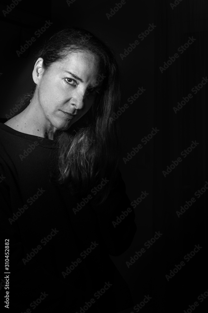 Portrait of mature beautiful woman looking camera with sensuality over black. Portrait of mature beautiful woman looking camera with sensuality over black.