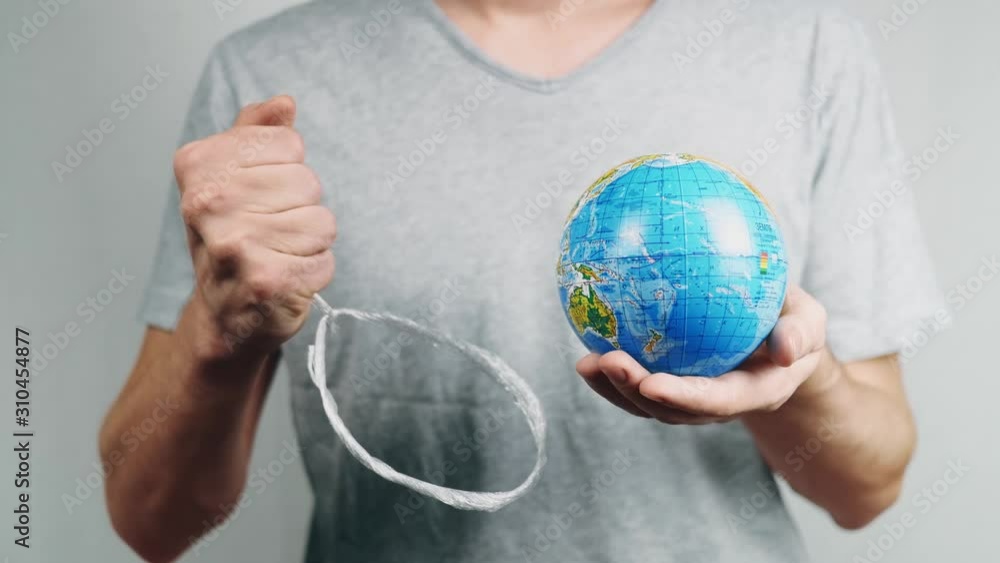 World Environment Day. Garbage gallows is killing the world. Male hand holds the earth in plastic loop. The globe with geographical names in Ukrainian cyrillic. Letters on it in polyethylene. World Environment Day. Garbage gallows is killing the world. Male hand holds the earth in plastic loop. The globe with geographical names in Ukrainian cyrillic. Letters on it in polyethylene.