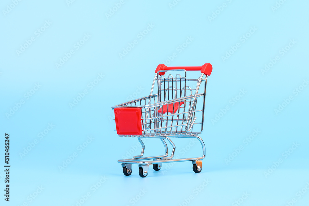 Shopping trolley or cart isolated on blue pastel background.