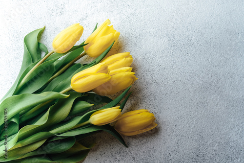 A bouquet of yellow tulips on a light background. Spring flowers.