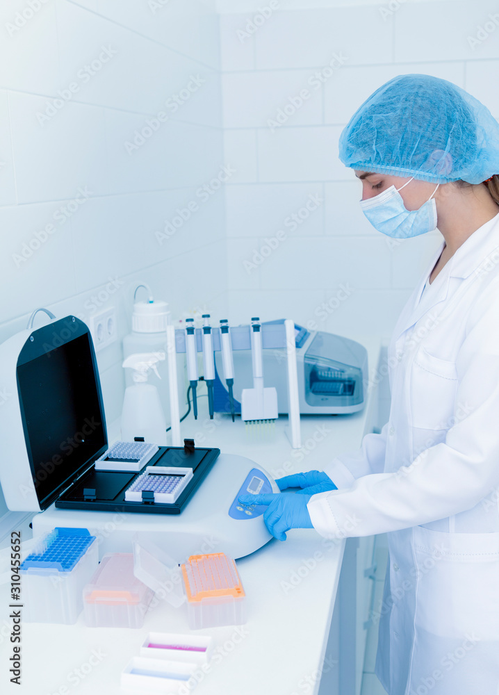 Young woman lab assistant tuning high quality equipment Young woman lab assistant tuning high quality equipment
