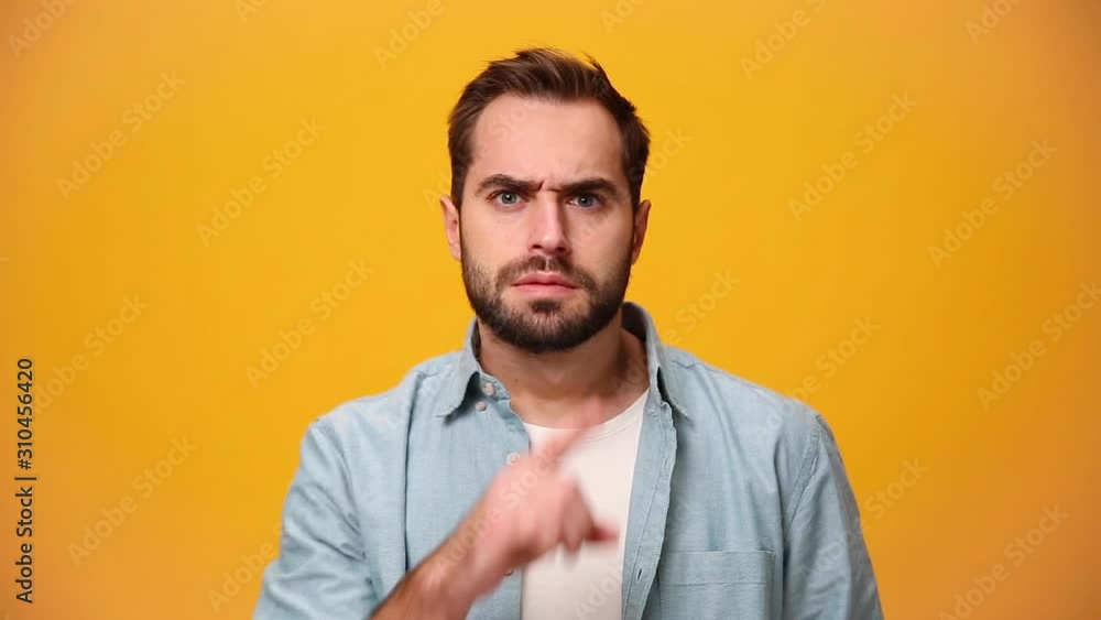 Anxious guy 20s in denim shirt white t-shirt isolated over yellow background in studio. People sincere emotions, lifestyle concept. Look at camera say hush be quiet with finger on lips shhh gesture. Anxious guy 20s in denim shirt white t-shirt isolated over yellow background in studio. People sincere emotions, lifestyle concept. Look at camera say hush be quiet with finger on lips shhh gesture.
