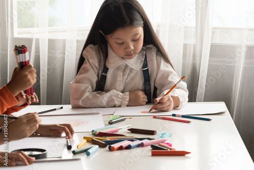Kids drawing with painting tools,color wooden pencil,crayon,draw together in class at school.