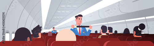 steward explaining passengers how to use seat belt fastening in emergency situation male flight attendants in uniform safety demonstration concept airplane board interior horizontal vector