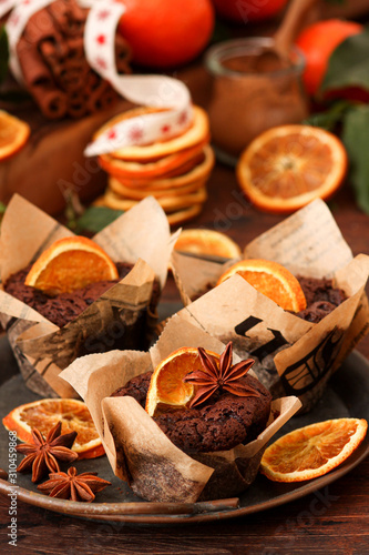 Fresh chocolate muffins with jam and spices on  rustic wooden background