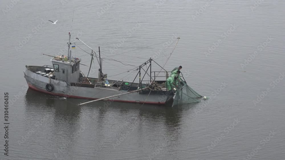 Mykolaiv, Ukraine - Oct 21 2019: Aerial view of a small fishing ship that catches fish with fishing nets in old trawling Mykolaiv, Ukraine - Oct 21 2019: Aerial view of a small fishing ship that catches fish with fishing nets in old trawling