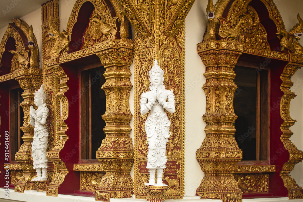Detail of a corner of Wat Buppharam temple with two white stucco Thai Style Angels praying, Chiang Mai