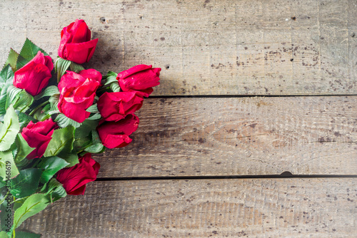 Valentine day greeting background with red rose flowers over wooden background