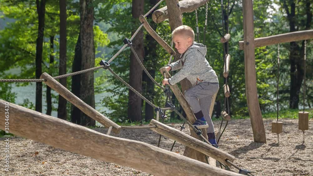 Young boy playing in playground in the woods Young boy playing in playground in the woods
