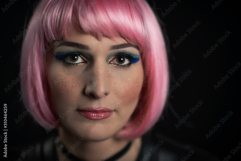 Portrait of girl on a black background with pink wig and colored lentigils