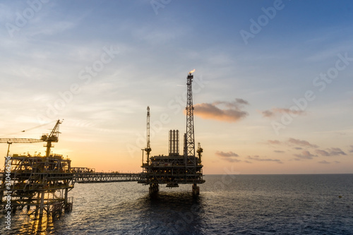 Silhouette of an oil production platform at oil field during sunset