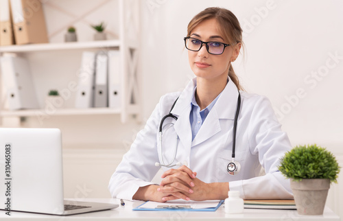 Lady Therapist Sitting Looking At Camera In Modern Clinic Office