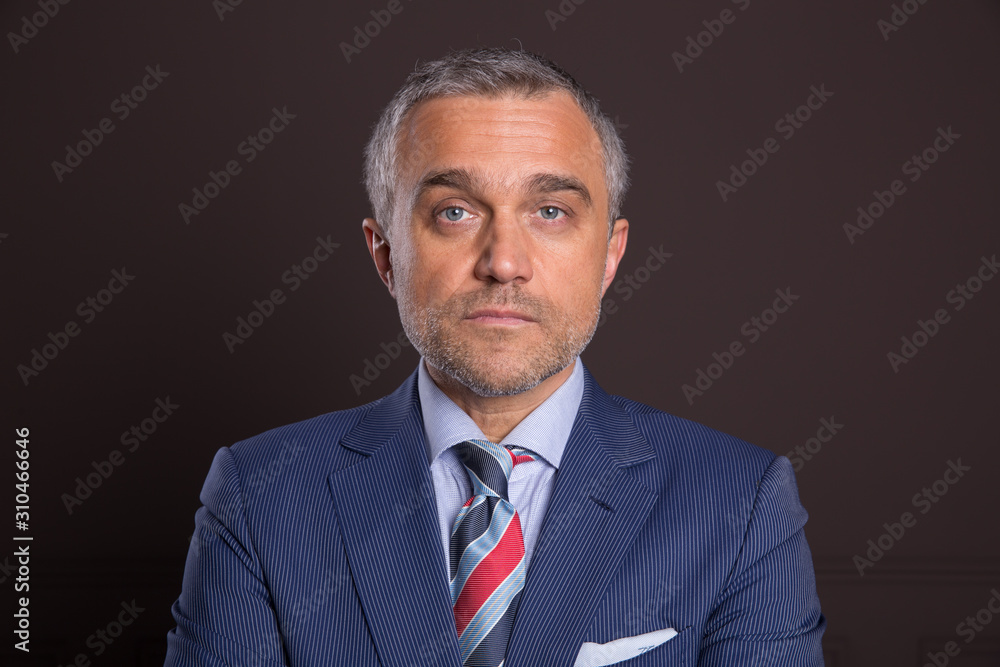 A portrait of a man on a matte brown wall in the background. A businessman. A portrait of a man on a matte brown wall in the background. A businessman.
