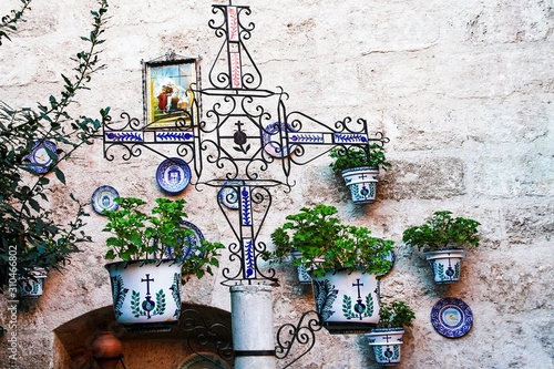 Facade of a traditional house with decorative ceramic plates and pots of flowers photo