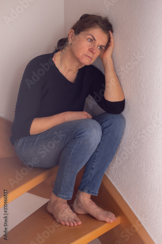 Woman sitting alone on the wooden stairs