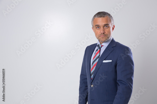 A portrait of a man on a matte brown wall in the background. A businessman.