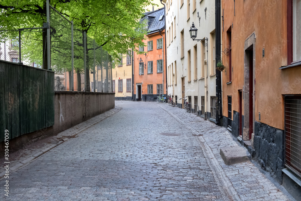 A modest deserted street, houses, trees and bicycles. Stockholm, Sweden.