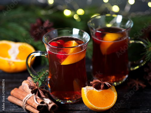 Two glasses of traditional Christmas and winter hot drink mulled wine of red wine with cinnamon, anise, berries and orange