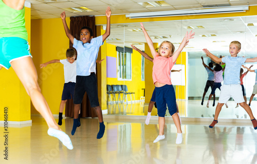 sportive children with teacher jumping together