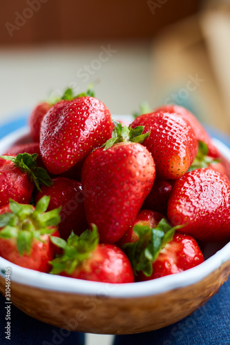 woman holding a bowl of freshly red strawberries
