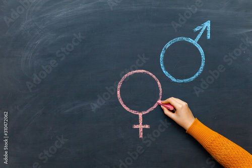 Quadro su tela Gender symbols or signs for the male and female sex drawn on a blackboard