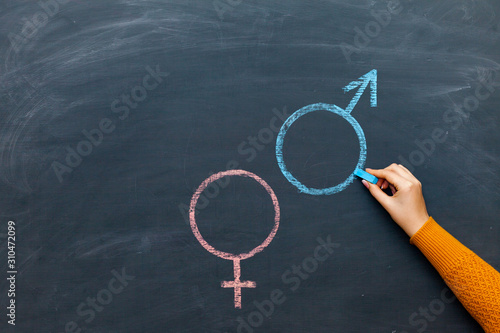 Foto Gender symbols or signs for the male and female sex drawn on a blackboard
