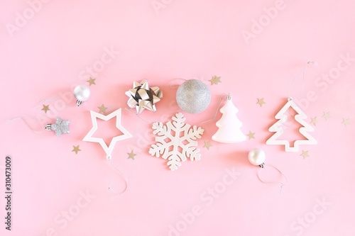 Christmas composition of white and silver decorations on a pastel pink background. Minimalistic holiday concept. Top view  flat lay.