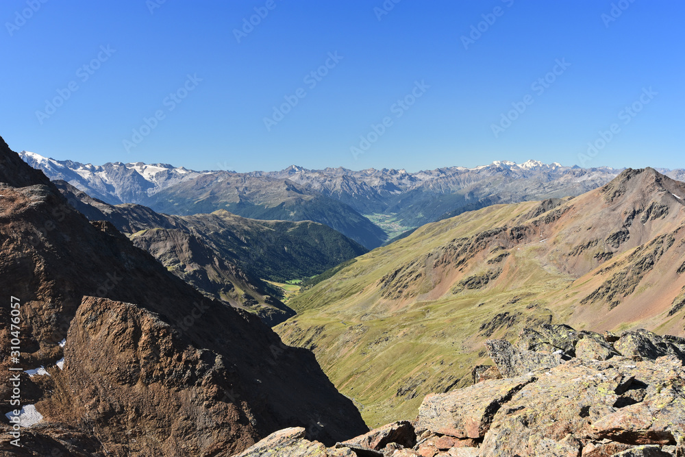 Alpine landscape with rocky mountains and green valleys under blue sky. South Tyrol, Italy
