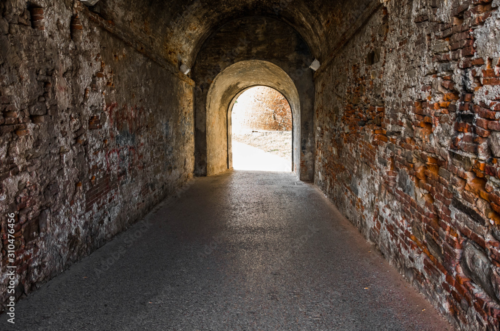 Old brick archway as a passage between the two wings of a medieval castle