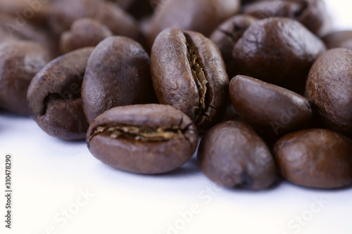 A group of freshly roasted coffee beans on a white background.Close-up, horizontal, macro, place for text.