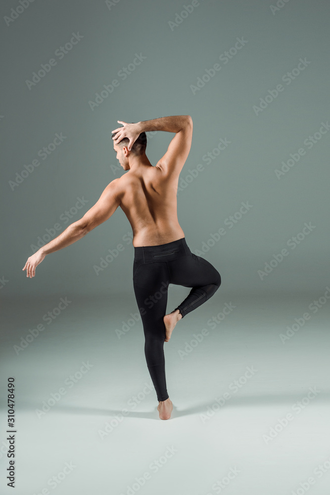 back view of dancer in black leggings dancing contemporary on dark background back view of dancer in black leggings dancing contemporary on dark background
