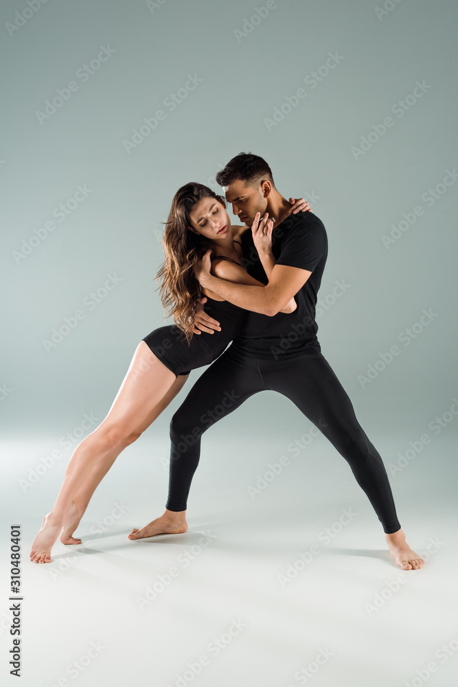 Obraz premium dancers with closed eyes dancing contemporary on grey background