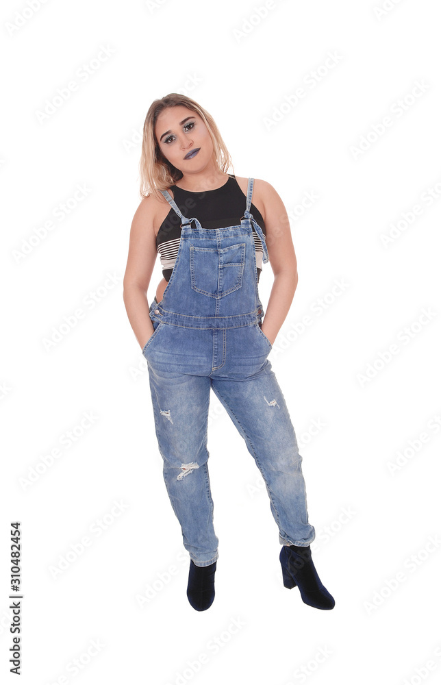 Young woman in working jeans standing in the studio Young woman in working jeans standing in the studio