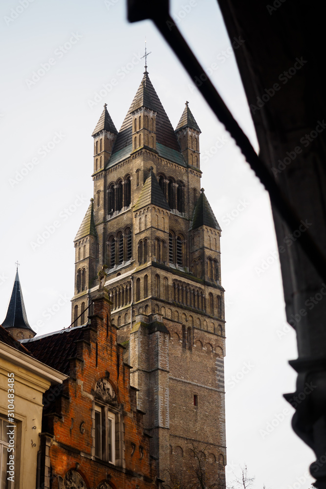  View of the tower of the Bruges market square from the typical streets of the Belgian city - Bruges, Belgium