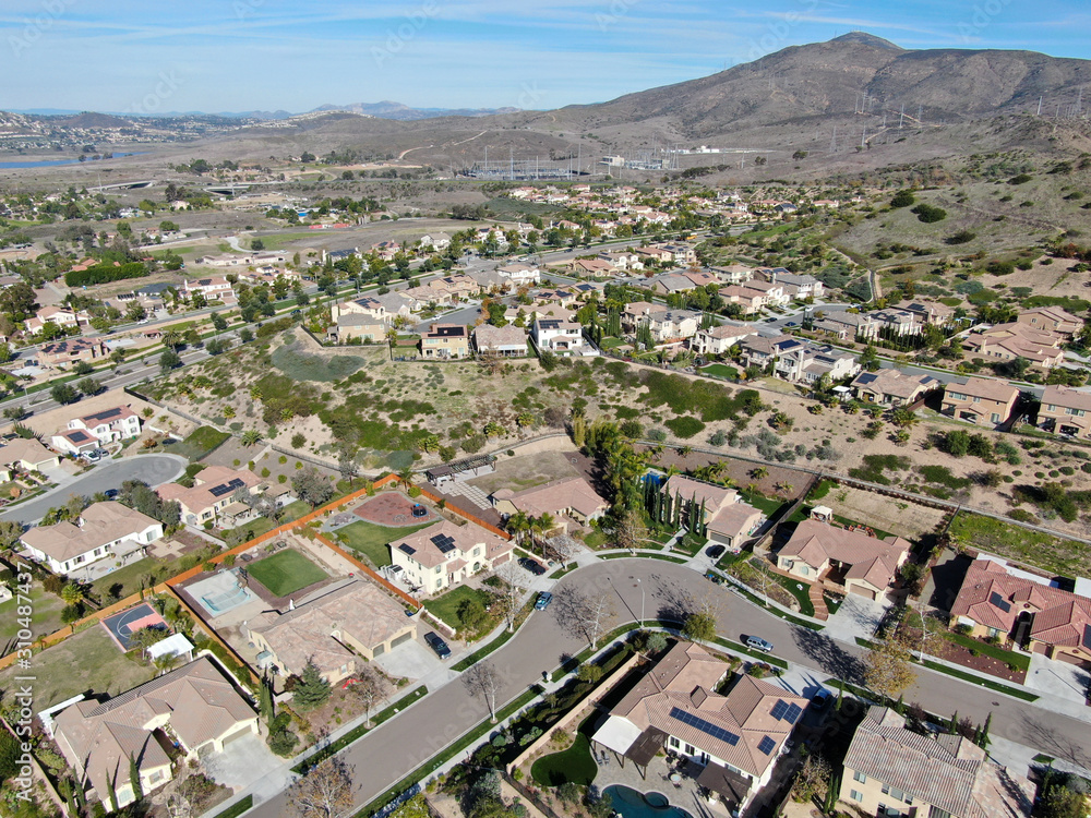 Aerial view of neighborhood with residential modern subdivision luxury houses and small road during sunny day in Chula Vista, California, USA.