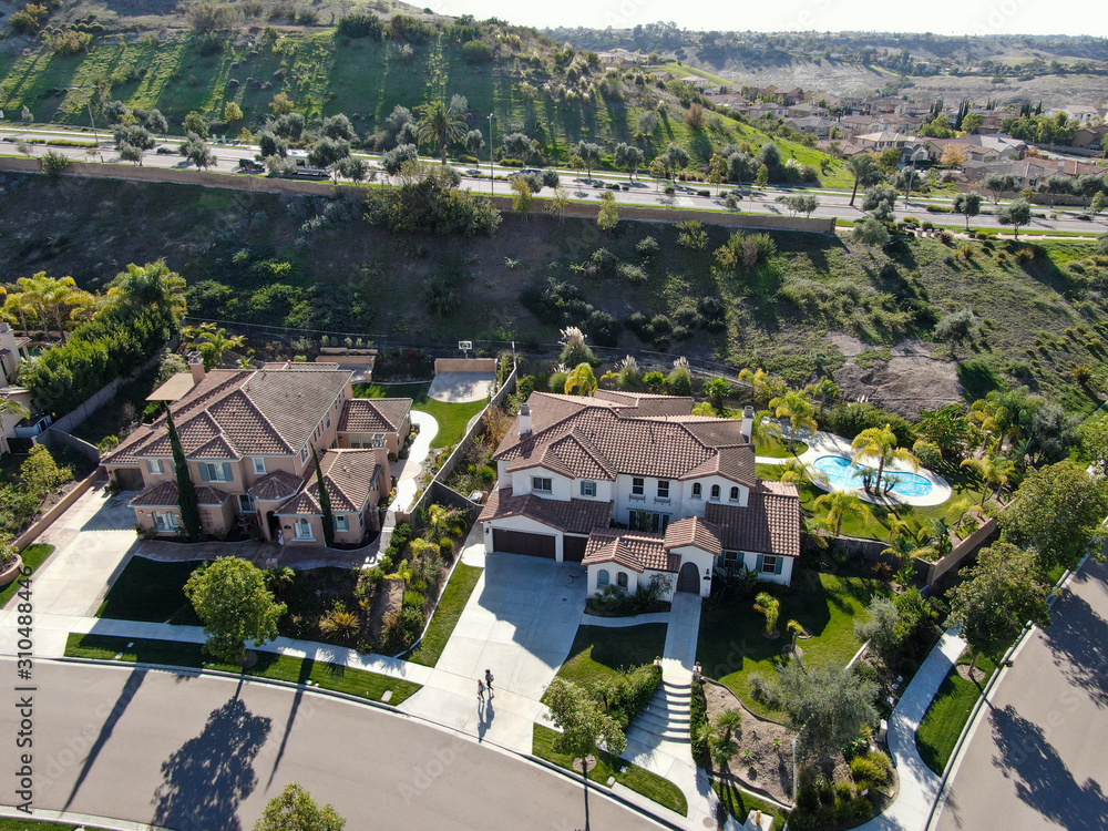 Fototapeta premium Aerial view of neighborhood with residential modern subdivision luxury houses and small road during sunny day in Chula Vista, California, USA.