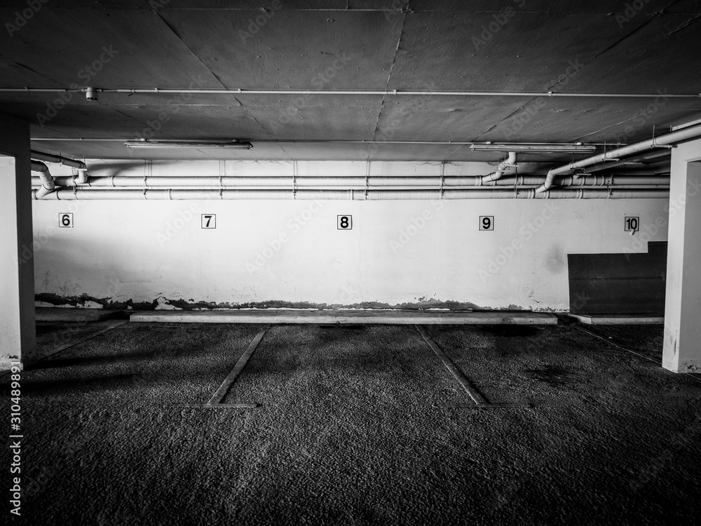 Creepy underground parking lot with electric strip lights and concrete